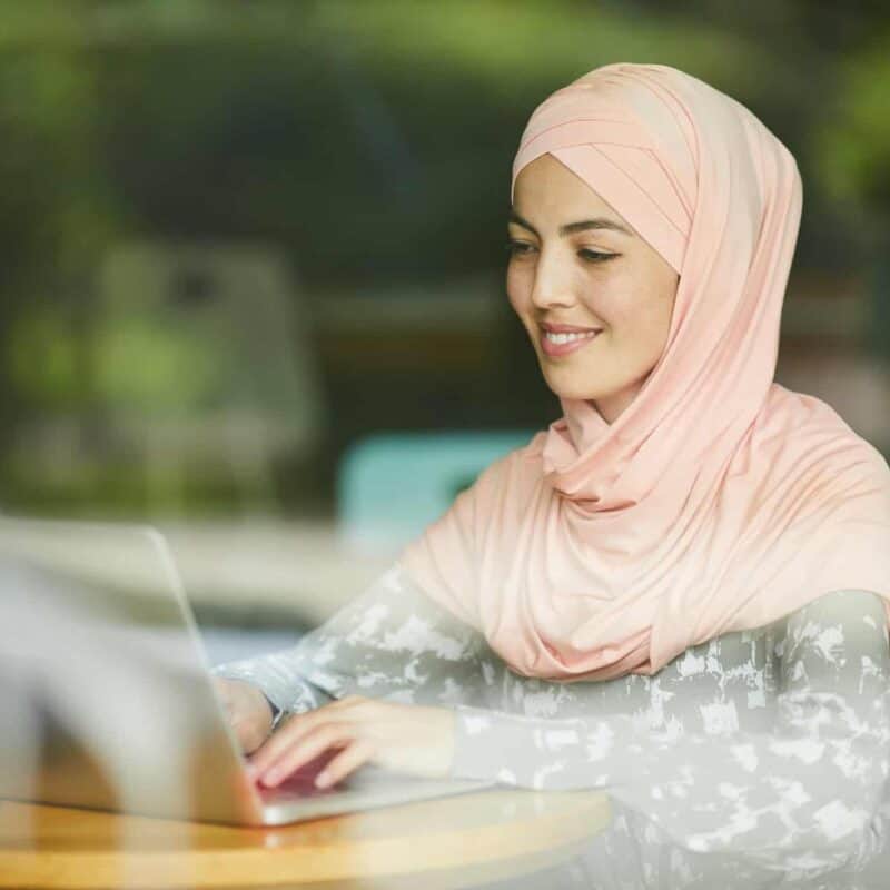 Muslim woman answering e-mails