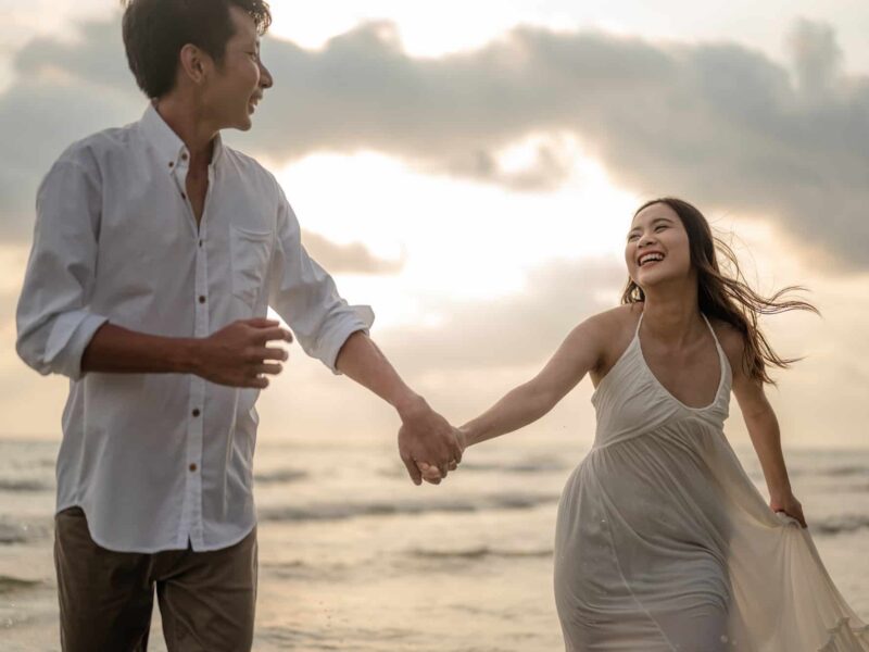 Portrait beach vacation romantic walk couple relaxing on ocean summer travel destination.